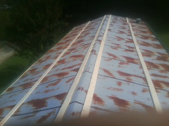 Rusted metal roof panels with new wood purlins before replacement — Storm Damage Roof Repair in Ruby by Roofing Brothers